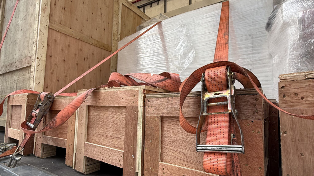 Wooden crates secured with straps inside a vehicle