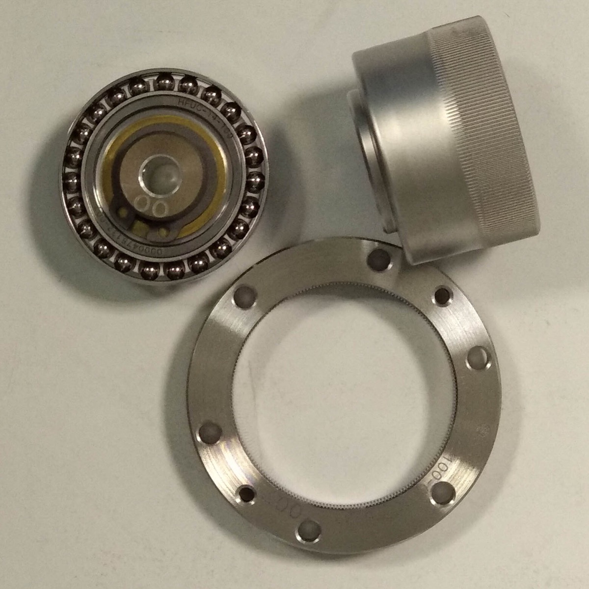 Disassembled strain-wave gear set showing the circular spline, flexspline and wave generator