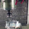 Real machining setup with external coolant nozzles arranged around the spindle above an accessible workpiece