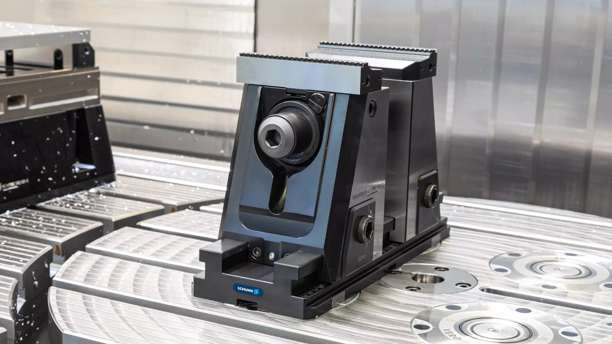 A vise and zero-point clamping modules on a machining-center table