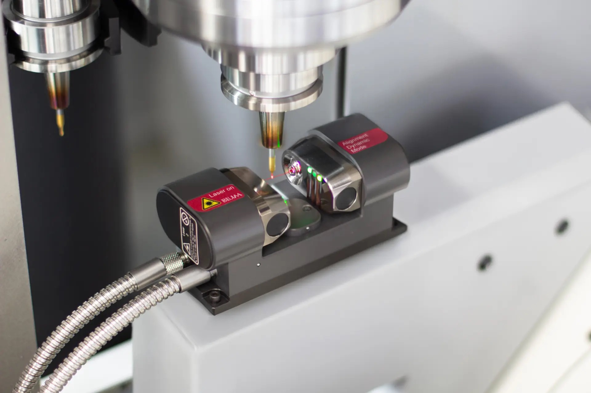 Blum laser tool setter mounted on a machine table, measuring a rotating tool held in the spindle