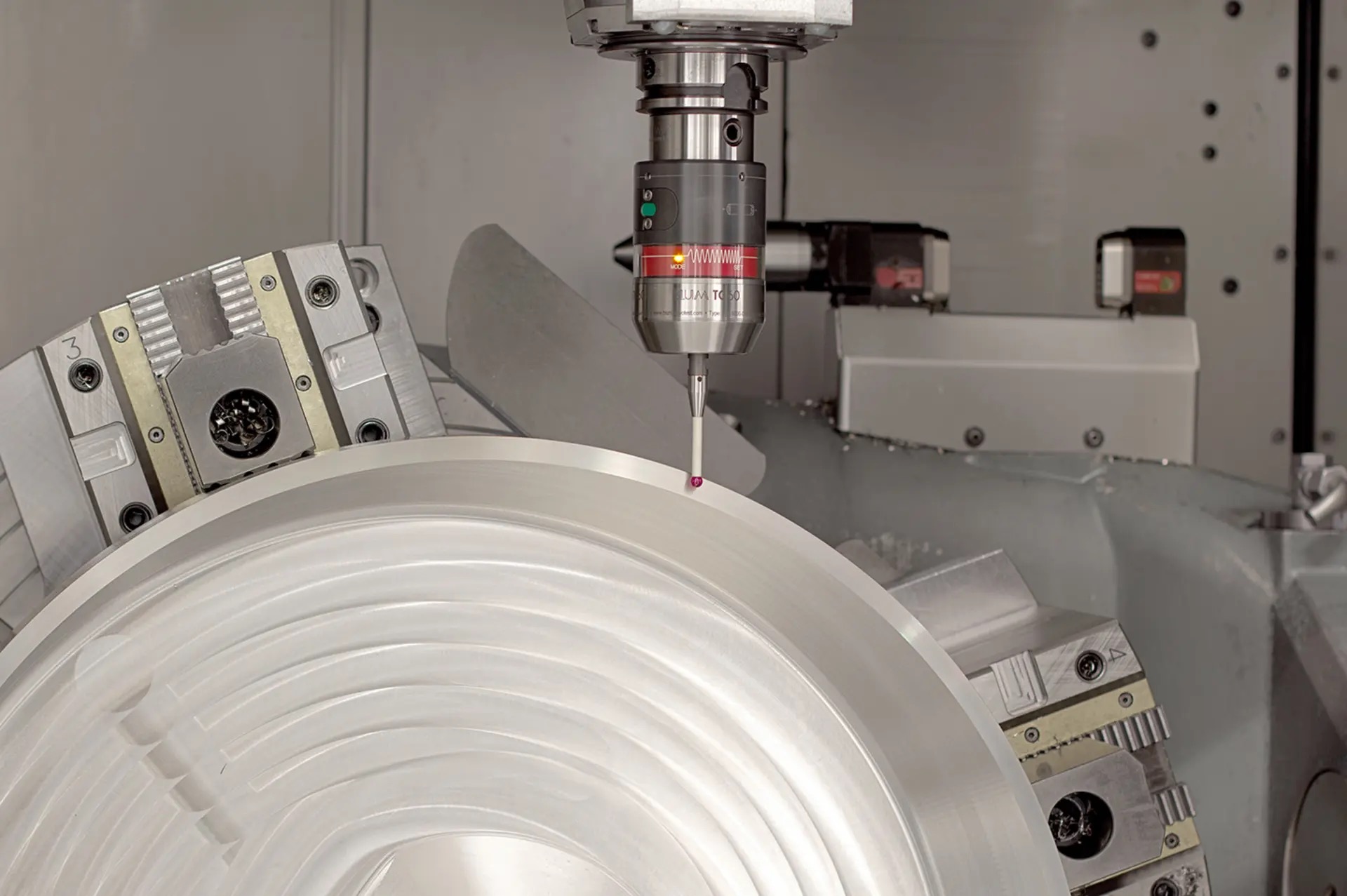 Touch probe in the spindle measuring a machined aluminium part on a rotary table