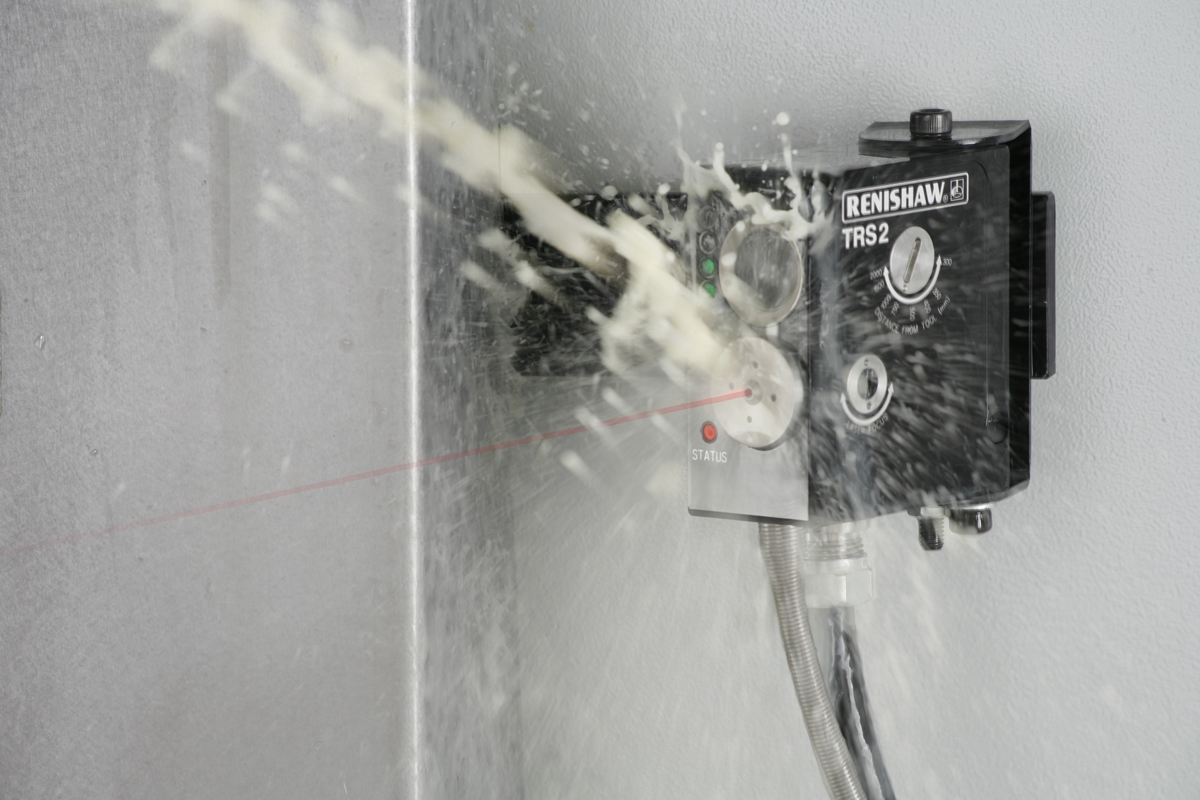 Renishaw TRS2 laser broken-tool detector mounted inside a machine with coolant spraying across it