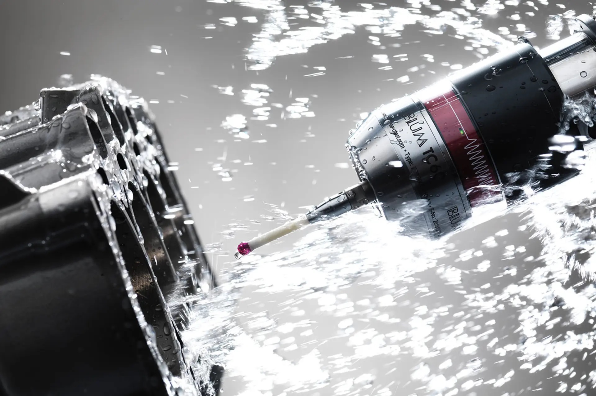 Touch probe measuring a workpiece through coolant spray inside a machine