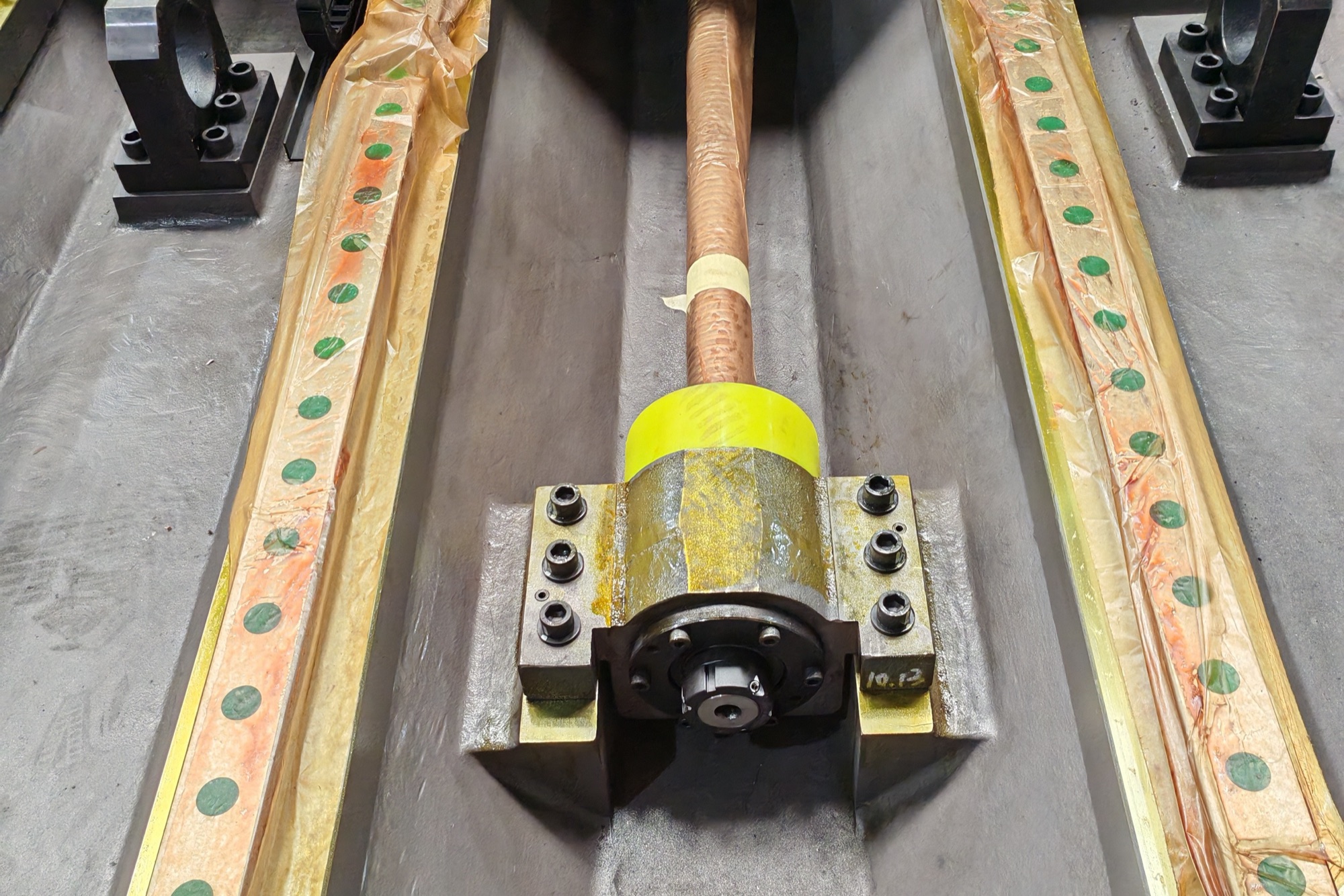Close-up of a large ballscrew and its support bearing block between two guideways on a CHANSIN machine base
