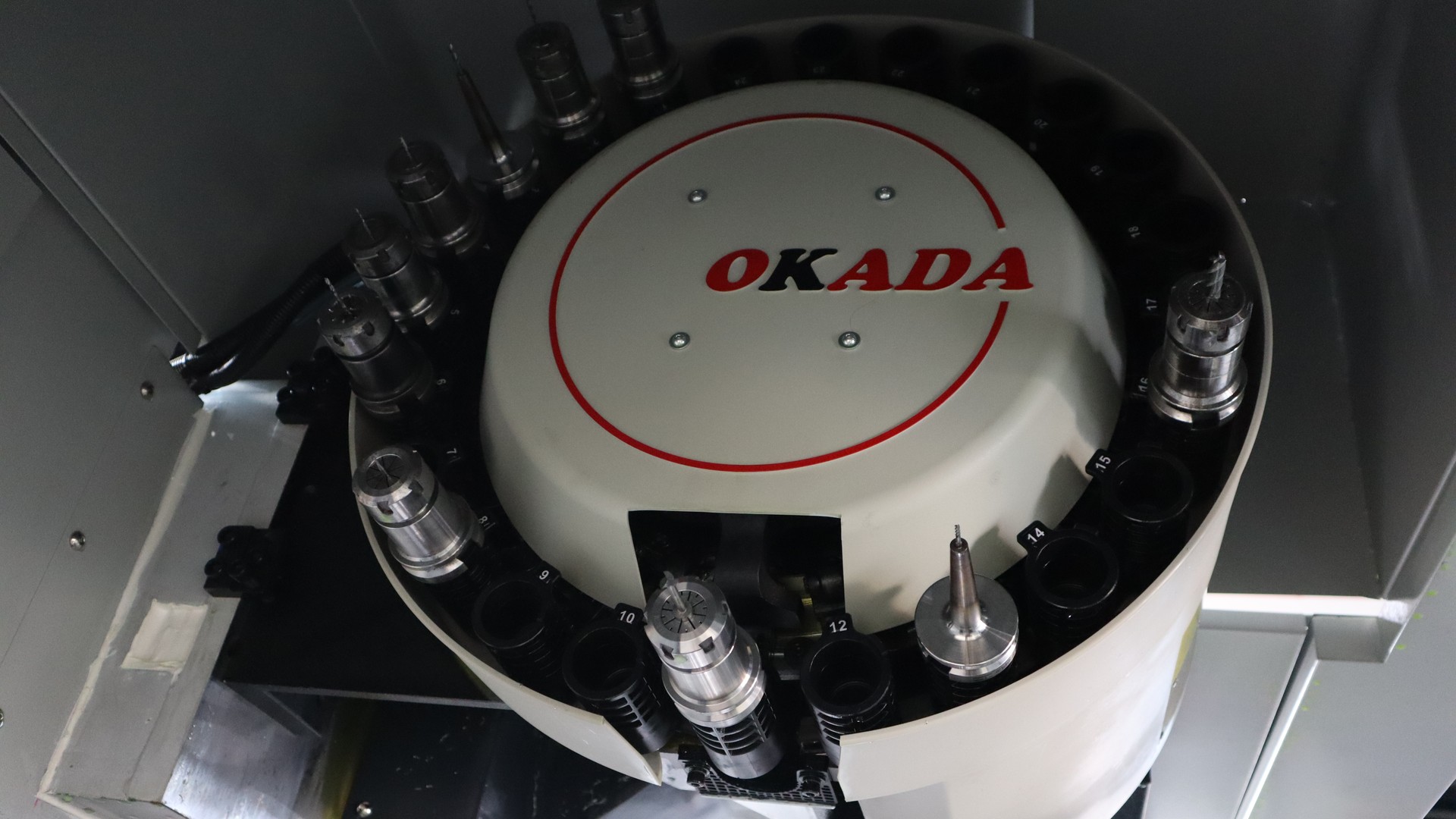 An OKADA disc tool magazine inside a CHANSIN CS-U480 machine, with toolholders in some numbered pockets and others empty
