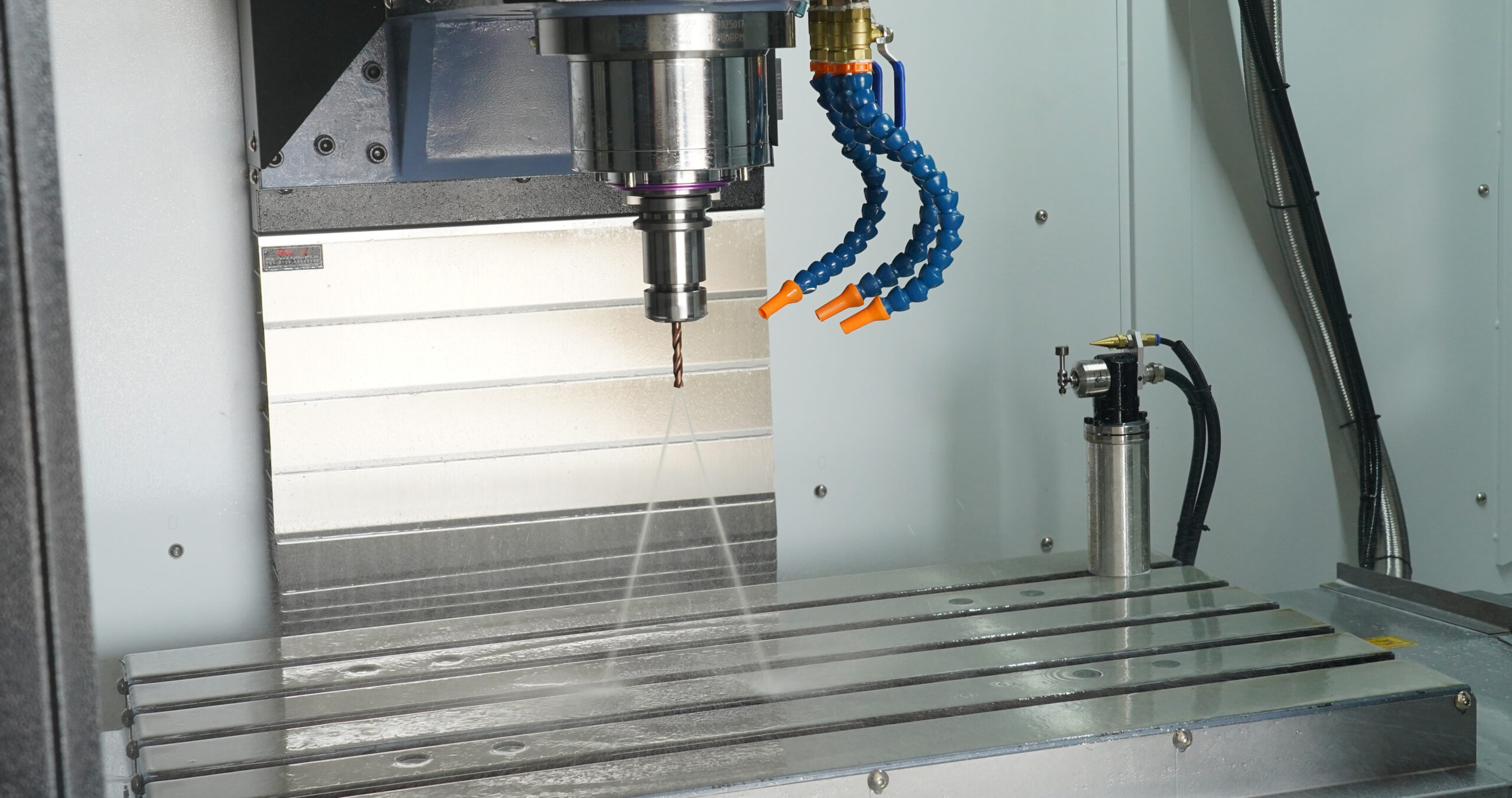 Table, spindle and coolant nozzles inside a CHANSIN machining center